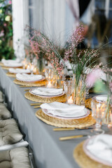 decorated with fresh flowers and served table for a festive dinner indoors