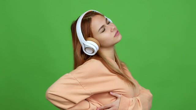 Teenager girl listening music with headphones suffering from pain in shoulder for having made an effort over isolated background