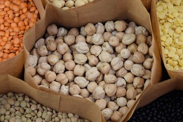 Chickpea in paper bag on background another legumes, uncooked chickpea seeds