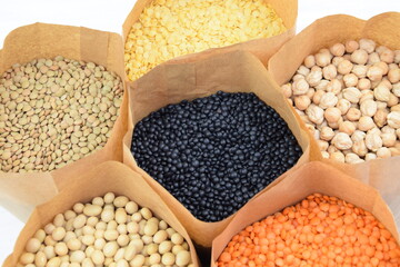 Paper bags of differrent legume on white background