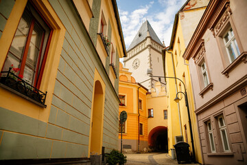 Fototapeta na wymiar Narrow medieval street with baroque and renaissance historical buildings, sunny summer day, gothic clock tower of Town hall with Hussitism museum, Tabor, South Bohemia, Czech Republic