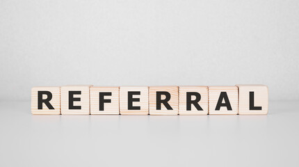 Word REFERRAL written on wood block. Business concept