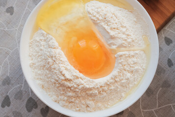 Egg in flour. Making dough concept. Top view, closeup