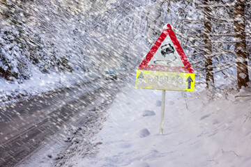 road sign warns of ice and snow at winter