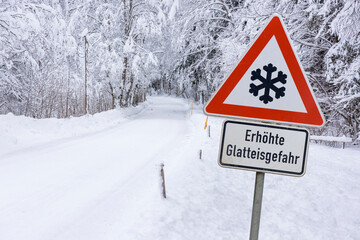road sign warns of ice and snow at winter