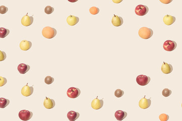 Creative pattern made with international fruits against soft pastel beige background. Minimal summer layout.