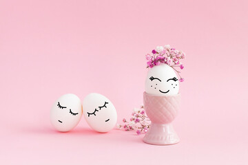 Easter eggs with flowers on pink background. Eggs with smiley faces. Drawn faces on eggs. 