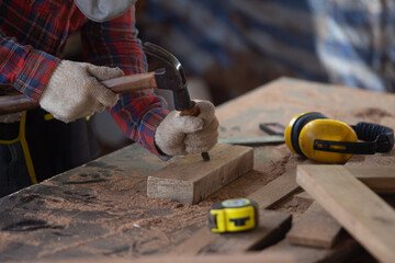 Closeup of a carpenter hands working with a chisel and hammer on wooden