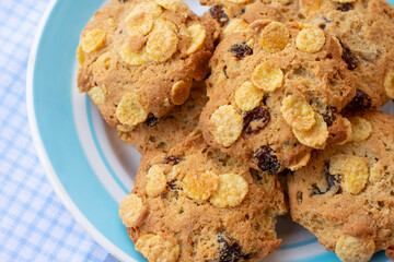 Group of cereal cookies in plate on table with tablecloth. Freshly baked oats biscuits.