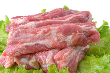 Raw pork ribs on a lettuce leaf are isolated on a white background.