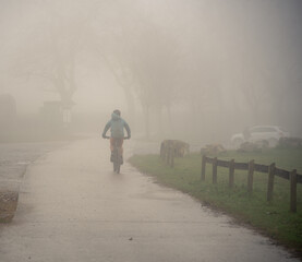 Un ciclista paseando por la montaña con niebla. 