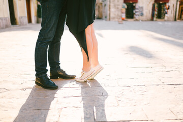 Closeup of couple's feet facing each other on a paved road