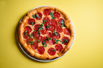 Pepperoni pizza centered on yellow background