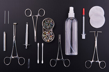 Piercing earrings, stainless steel clips for disinfection on a black background
