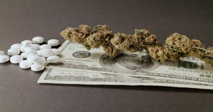 Weed Buds on top of Dollar Bills. Drugs on 100 Dollar Banknotes, purchasing Illegals substances