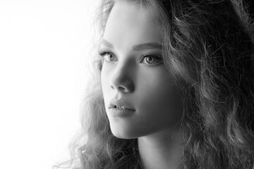 Fototapeta premium Curly girl on white background. Black and white portrait of beautiful young woman. Free space for text.