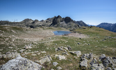 Fototapeta na wymiar View of Port de Ratera (Ratera pass) and the glacial lake as seen from GR11 trail to refuge Colomers, Aiguestortes and Estany de Sant Maurici National Park, Pyrenees, Spain.