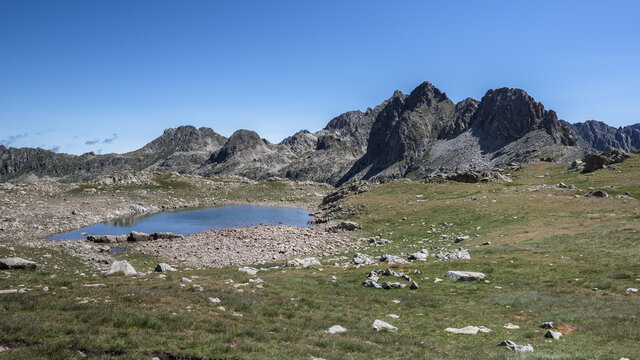 View of Port de Ratera (Ratera pass) and the glacial lake as seen from GR11 trail to refuge Colomers, Aiguestortes and Estany de Sant Maurici National Park, Pyrenees, Spain.