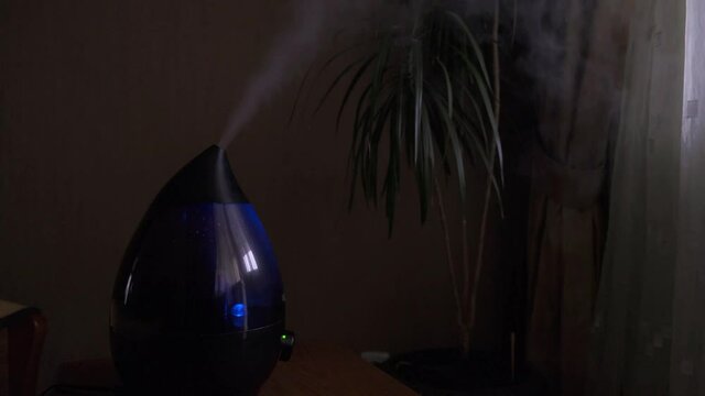 Steam from a modern air humidifier in dark room. Close-up, no people.