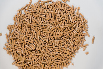 Heap of pellets for heating on a white background. View from above. Sustainability concept