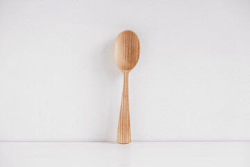 Empty wooden spoon on a white table background. Copy, empty space for text