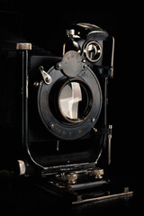 Vintage camera on a black background. Close-up of the lens of an old camera open.