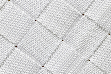 Abstract alternating diagonal pattern made up of squares of woven white nylon.