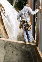 Mason looking down at fresh concrete