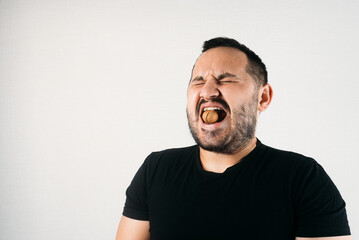 a man tries to crack a nut with his teeth. the concept of a complex problem or strong teeth