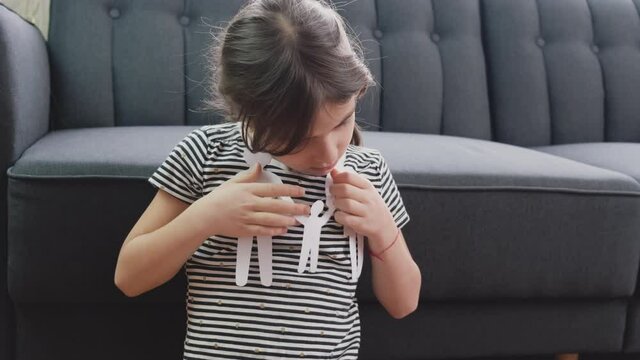 child holds a paper-cut family in her hands. selective focus.