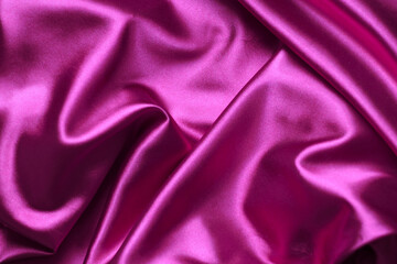 Pink silk background, satin fabric background. Pleated fabric.