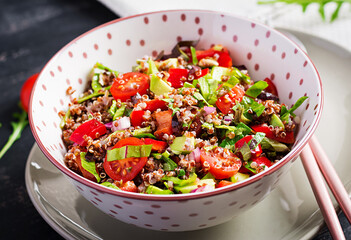Tabbouleh with quinoa. Tabbouleh salad - traditional Middle Eastern or Arabic cuisine. Vegetarian salad with quinoa, tomato, avocado, green herbs and lemon juice. Vegan and vegetarian meal