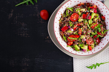 Tabbouleh with quinoa. Tabbouleh salad - traditional Middle Eastern cuisine. Vegetarian salad with quinoa, tomato, avocado, green herbs and lemon juice. Vegan and vegetarian meal. Top view, above