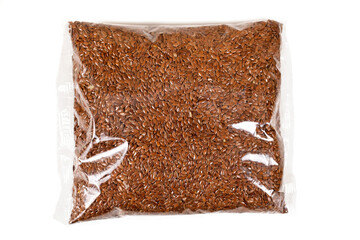 Brown linen seeds in a transparent plastic bag isolated on a white background. Top view.