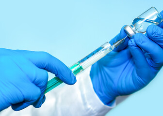 Vaccine in a bottle with a syringe on a blue background.The concept of medicine, healthcare and science.Coronavirus vaccine.Copy space for text.