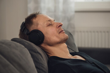 The man in the headphones enjoys listening to music.