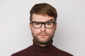 Fototapeta premium studio portrait of a frowning guy on a light background