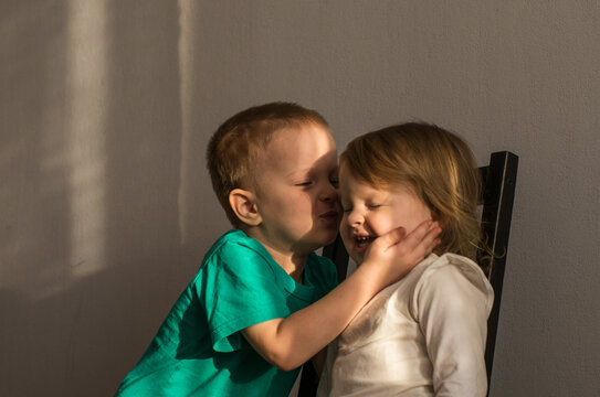 a little boy kisses his little sister. the relationship of the siblings. children laugh