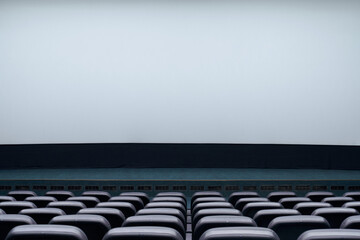 Obraz premium Large blank screen and rows black seats in cinema hall.