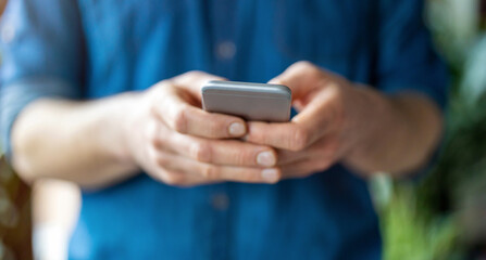 Male hands typing on smartphone
