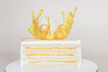 Exotic cake cutaway with white chocolate spheres and caramel splash decorated with candurin