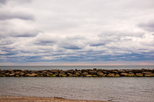 Clouds over the Lake Ontario seen over rock breack water