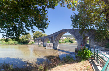 Fototapeta na wymiar The famous stone bridge of Arta, a bridge of four arches over Arachthos river. Many popular legends describe the building of the bridge, among the the sacrifice of master builder's wife. 