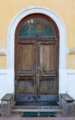 Fototapeta na wymiar Old wooden skewed door on the street.