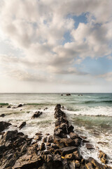 Fototapeta na wymiar Grupo de rocas en hilera entrando en el mar.