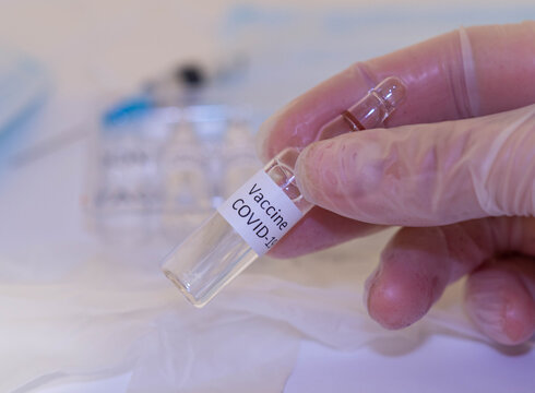Medical doctor or laborant holding tube with nCoV Coronavirus vaccine for 2019-nCoV COVID virus.