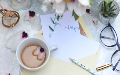 Top shot of a table with a cup of coffee and a bouquet of spring flowers on a white table top. coffee, place for text , flat lay