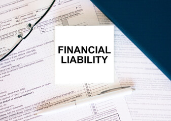 Tax form with business card with text Financial Liability. Notepad, eyeglasses and white pen