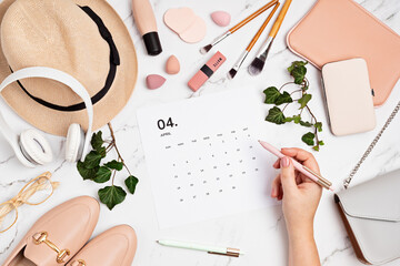Flat lay with calendar for april with woman fashion spring accessories. Social media blog,...