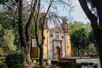 Fototapeta na wymiar Old Mexican Church surrounded by trees in Coyoacan